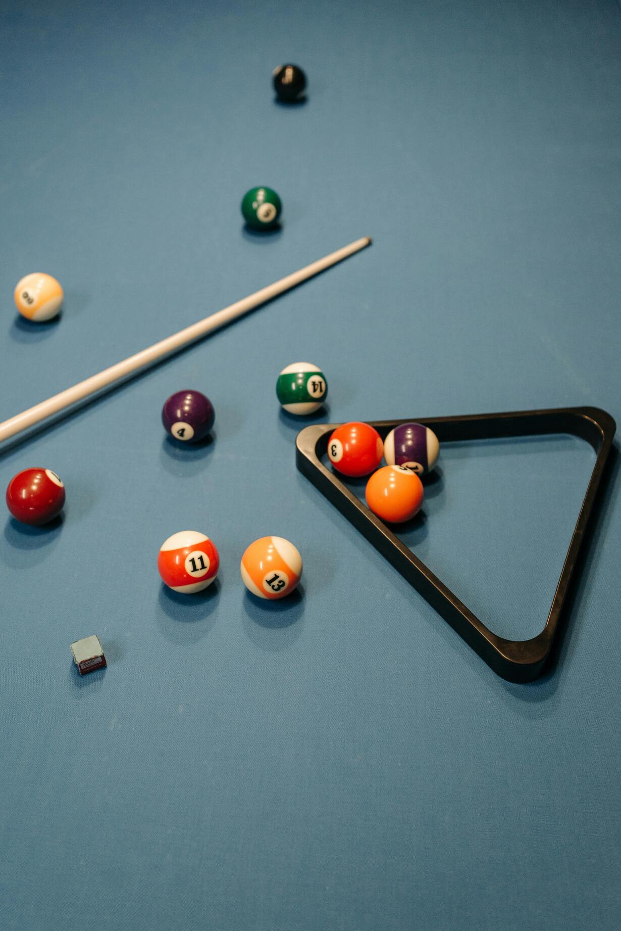 Billardtisch mit Kugeln, Queue und Dreieck für das Spielaufbau.